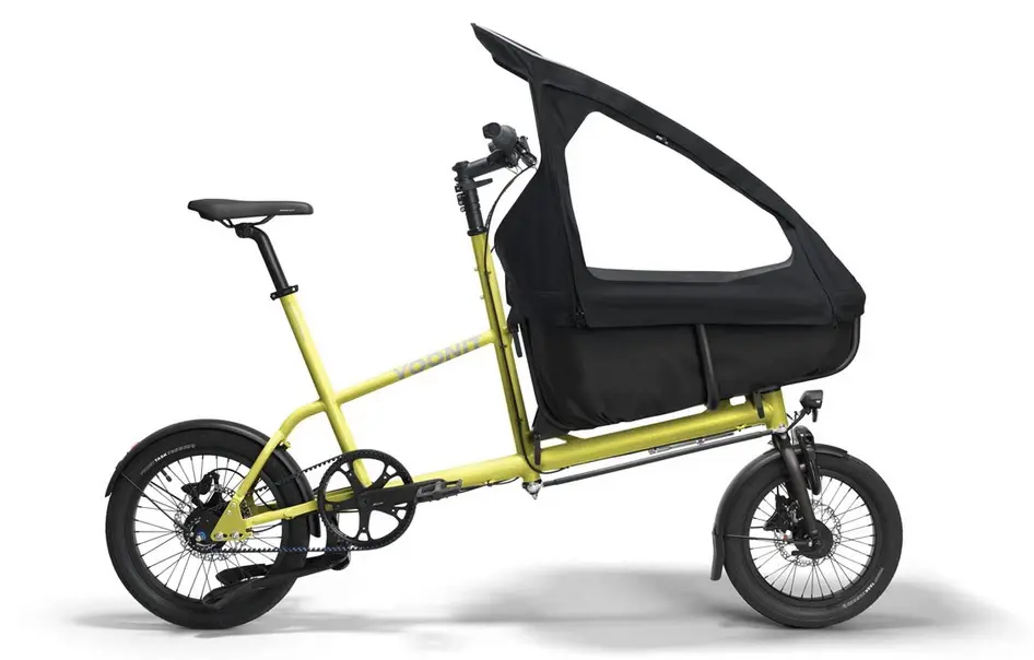 Yellow cargo bike with a large black canopy over the cargo area for a child passenger