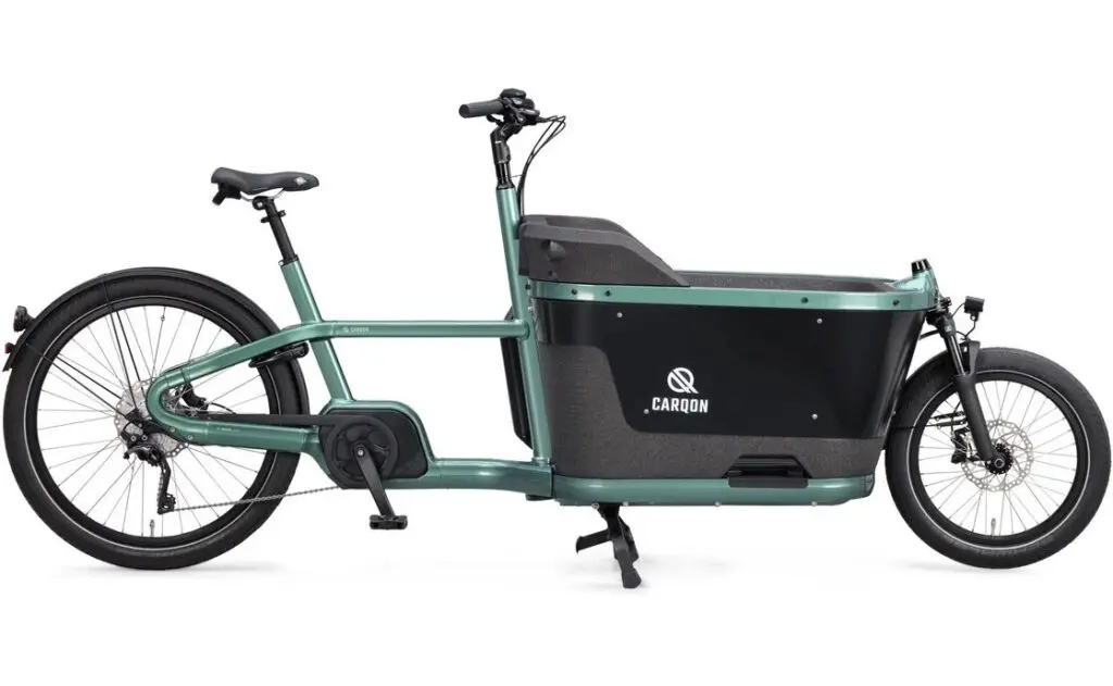 Green electric cargo bike with a large black front cargo box, on a white background, brand CARQON visible on the side.